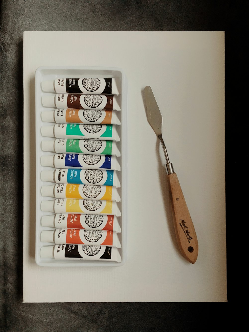 a tray of paint and a brush on a table