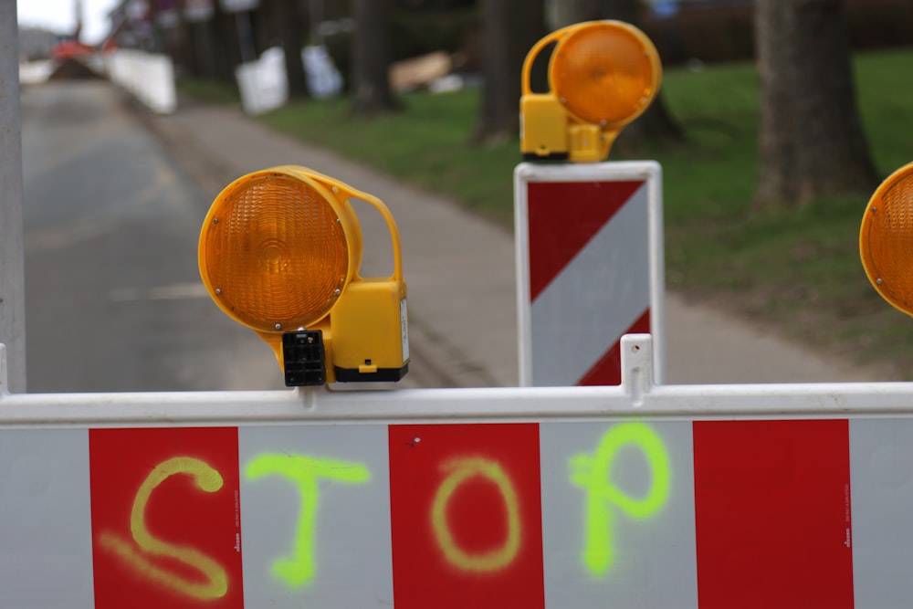 a stop sign with two traffic lights on top of it