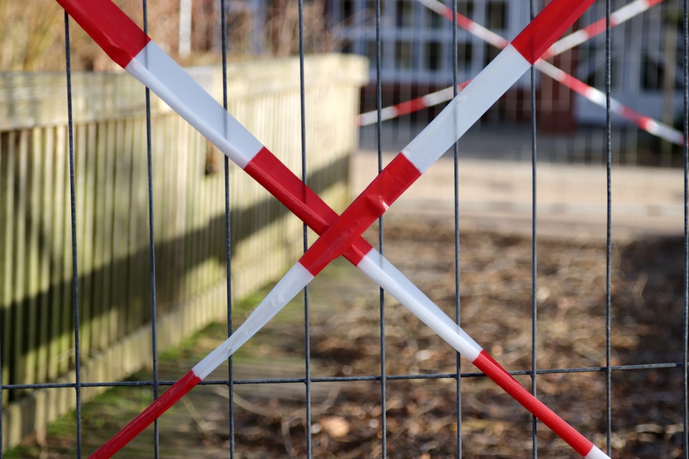 a red and white fence with two red and white poles sticking out of it