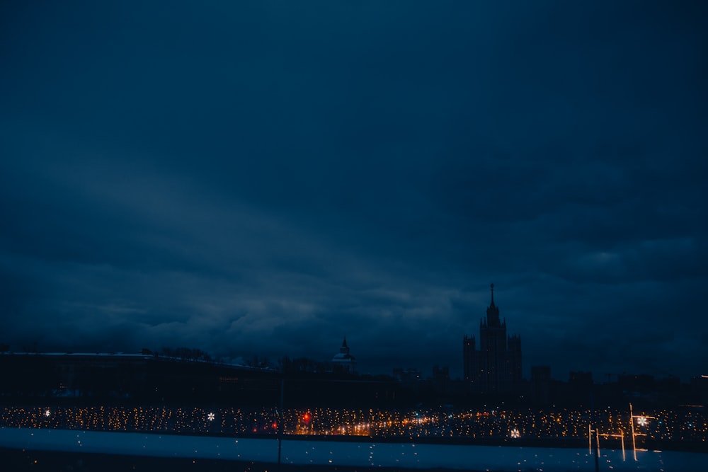 a city skyline at night with a dark sky