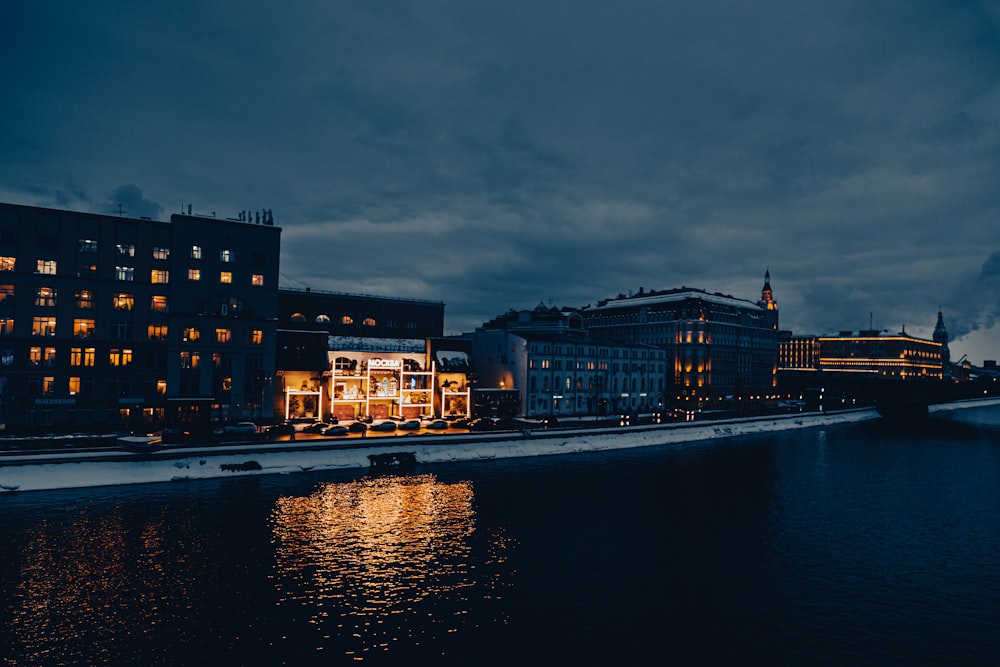 a body of water with buildings lit up at night