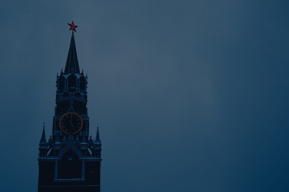 a tall clock tower with a red star on top