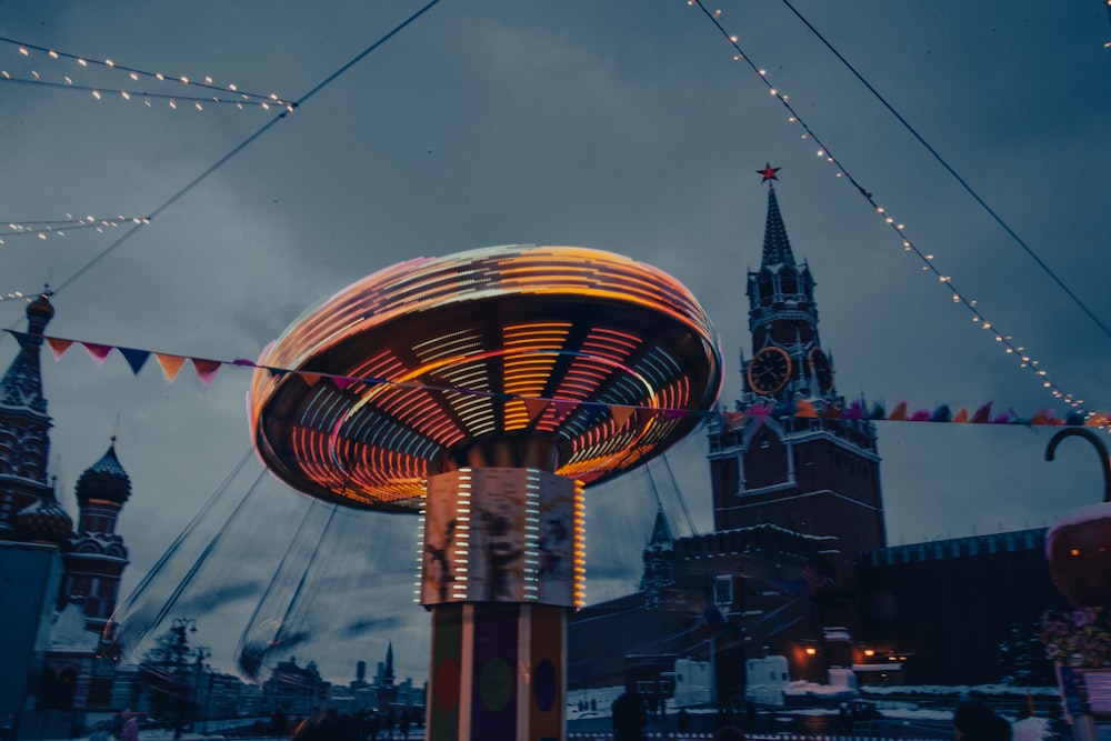 a merry go round in front of a clock tower