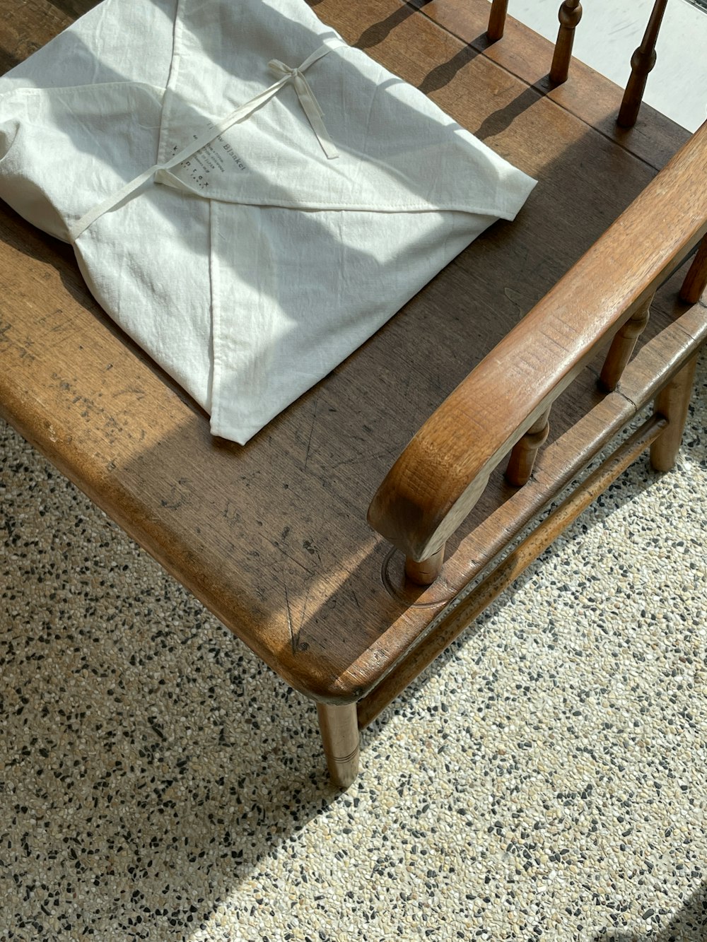 a wooden chair with a white cloth on top of it