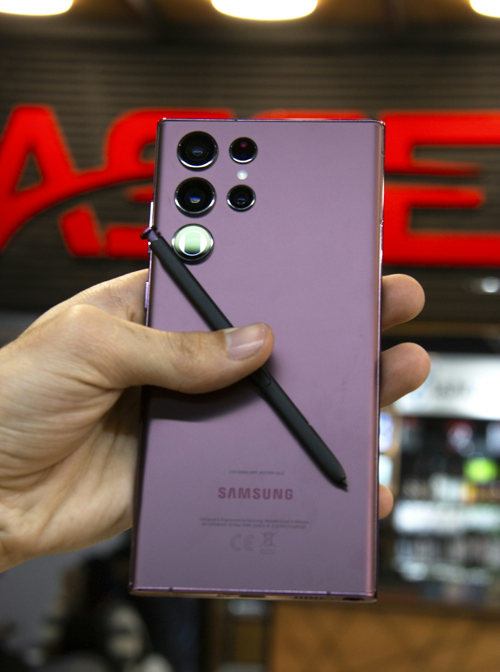 a person holding a purple samsung phone in their hand