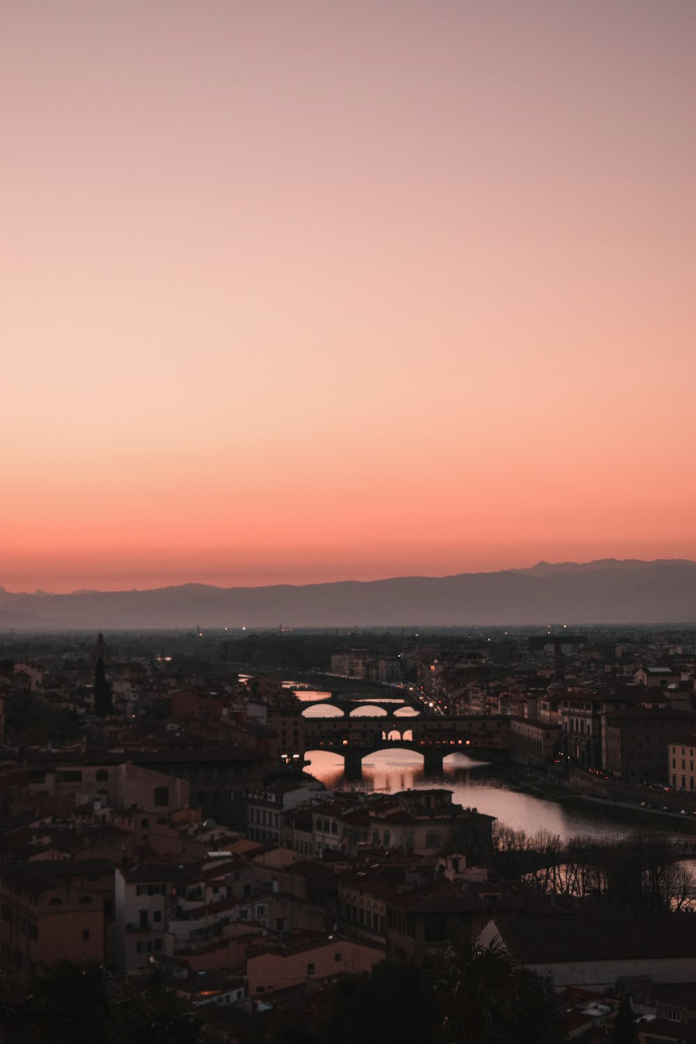 a view of a city and a river at sunset