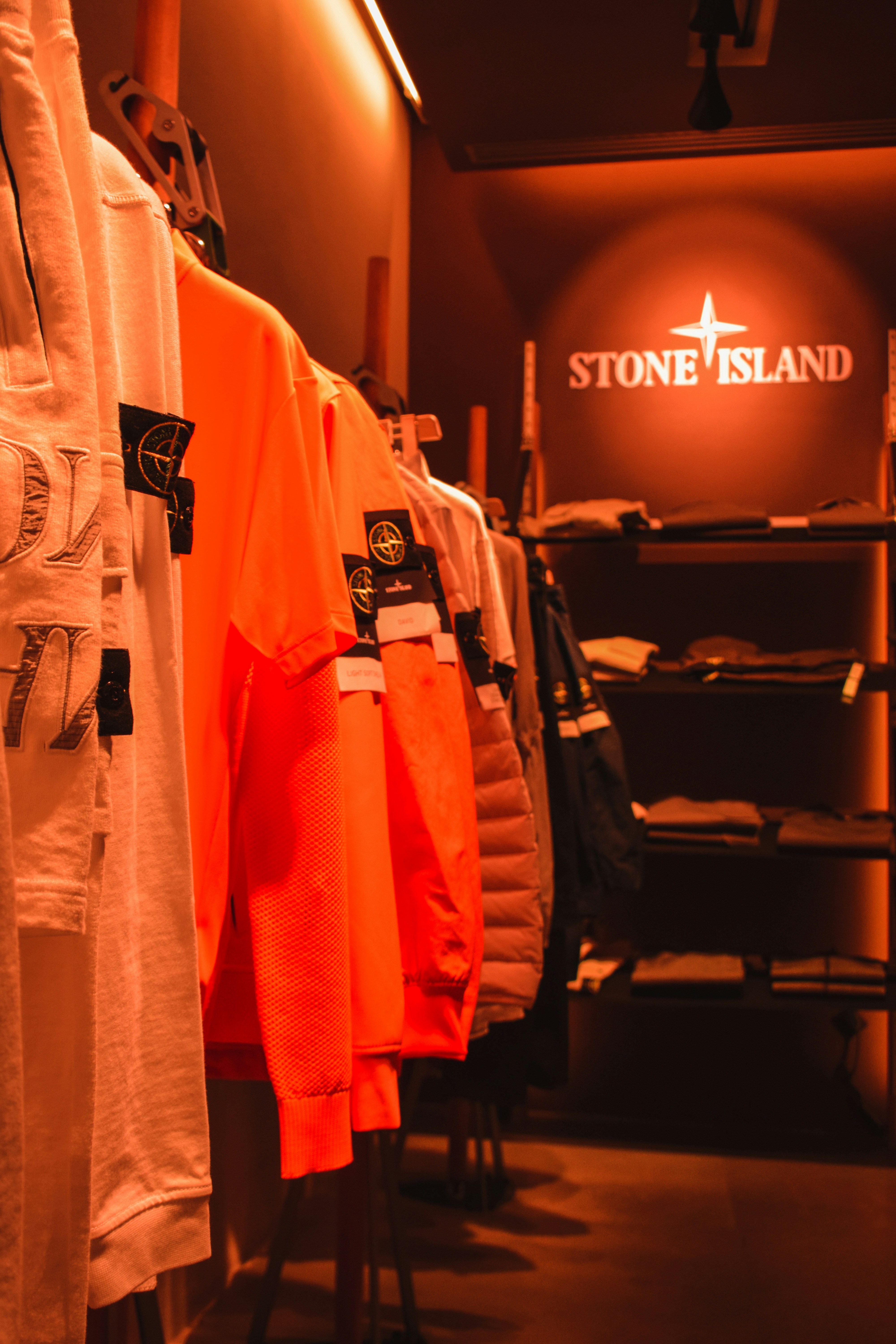 A store rail filled with lots of orange shirts