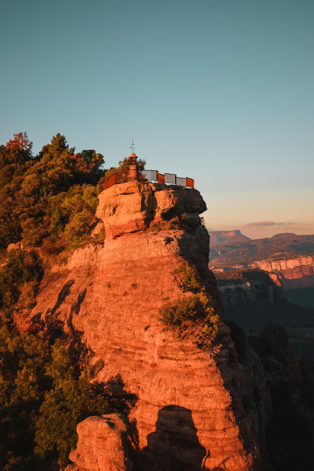 a couple of people standing on top of a cliff