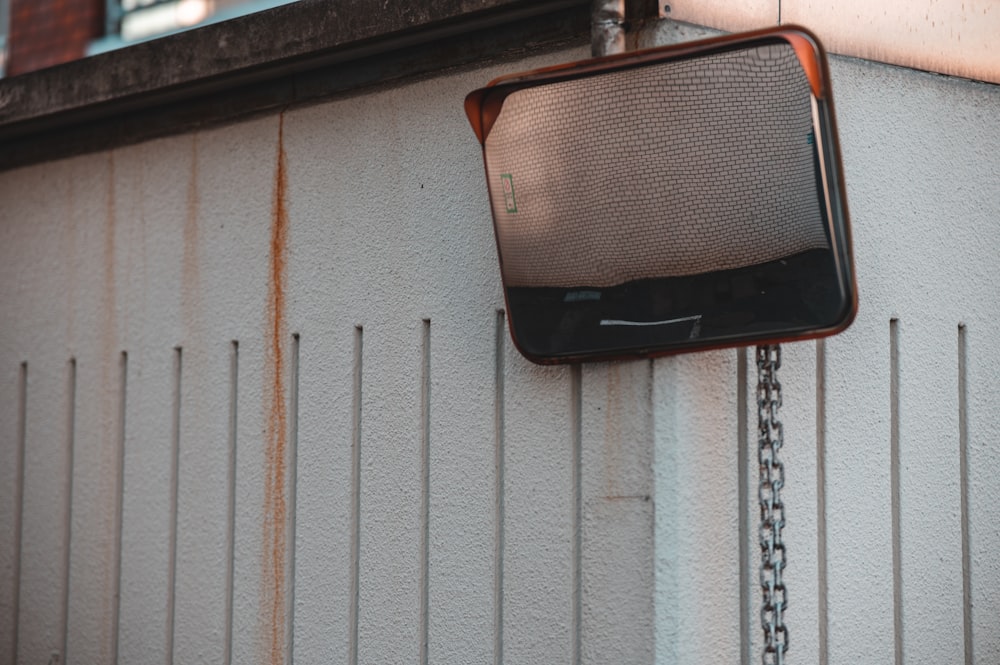 an old tv mounted to a wall on a chain
