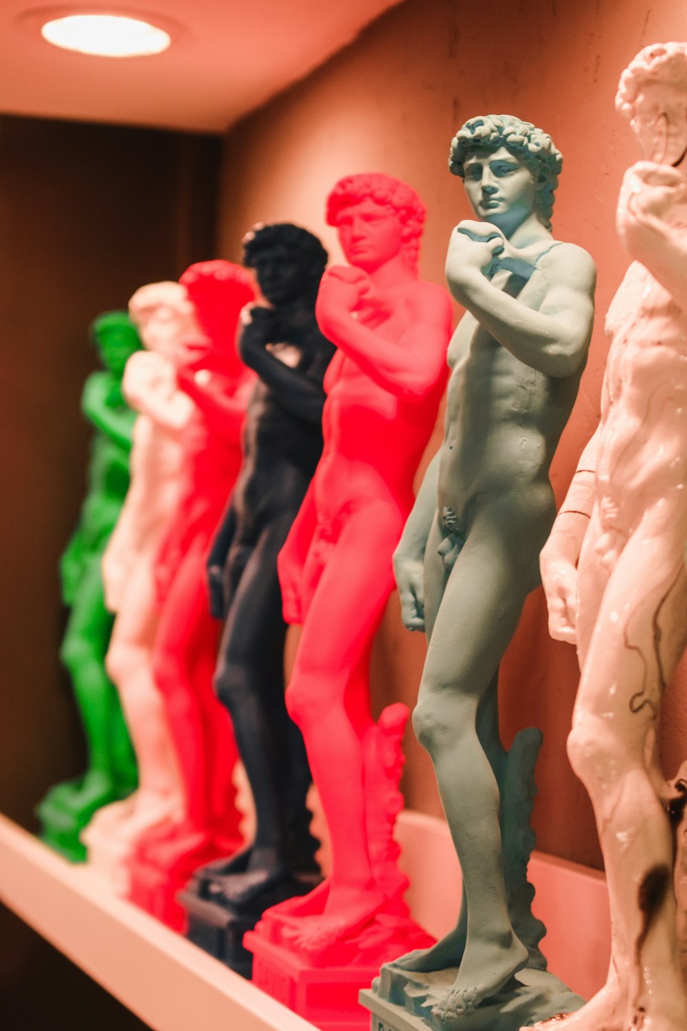 a row of colorful statues sitting on top of a shelf