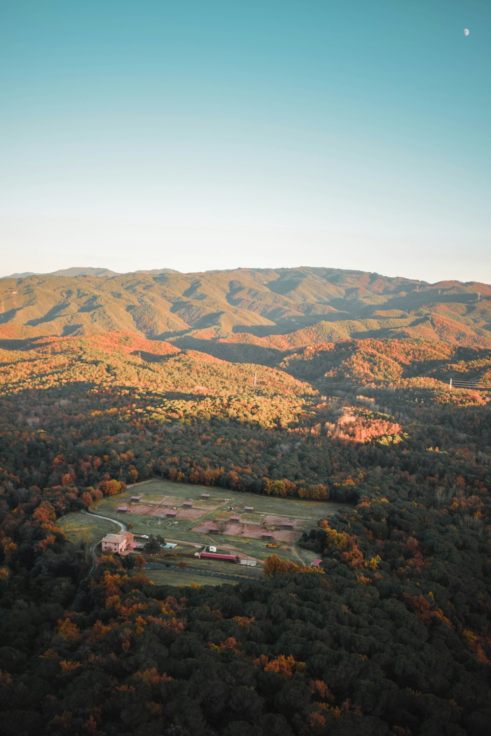 an aerial view of a large field surrounded by mountains