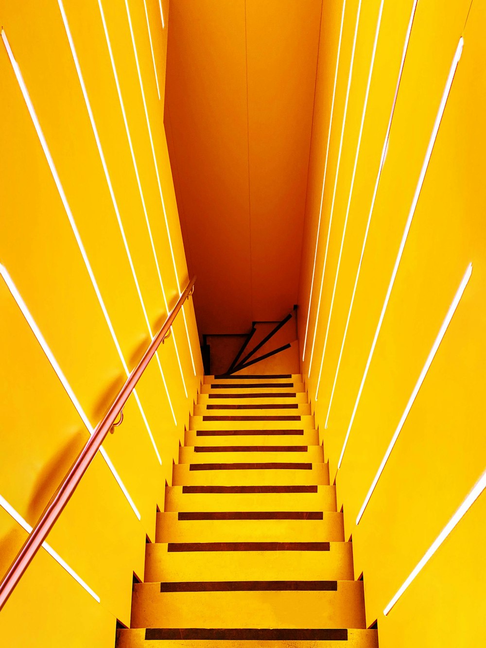 a set of stairs leading up to a yellow wall