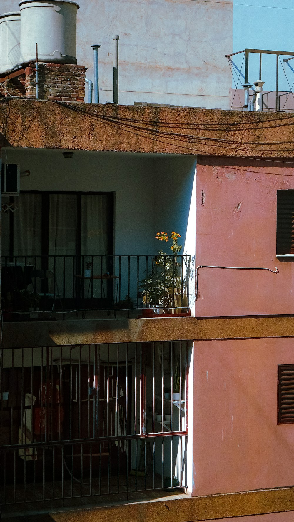 a pink building with a balcony and balcony railing