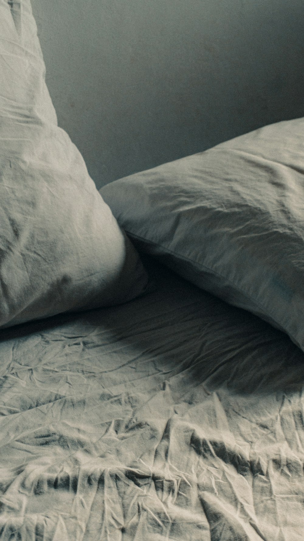 a black and white photo of a bed with two pillows