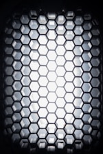 Close-up of a glowing graphene lattice structure with orange highlights on a black background.