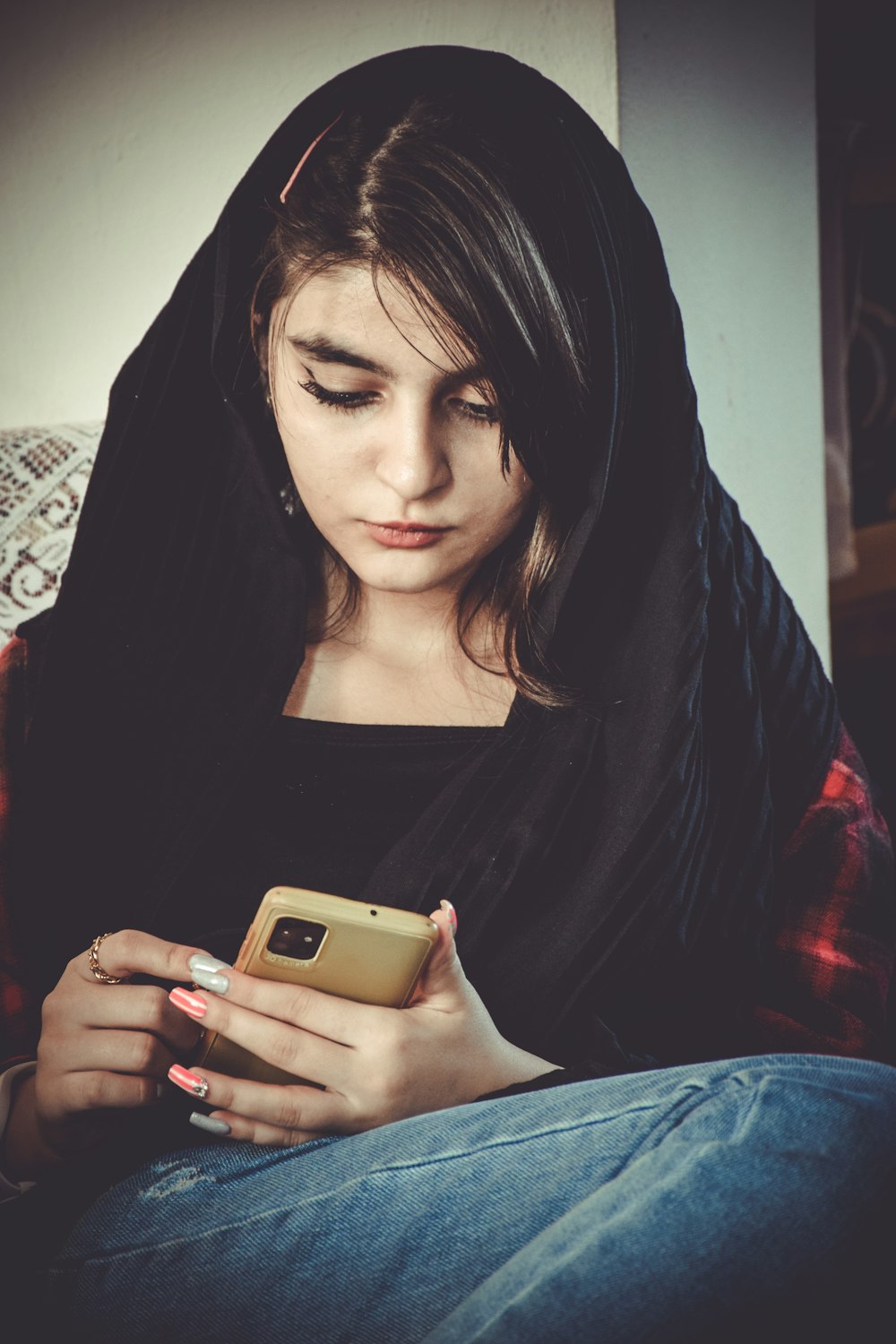 a woman sitting on a couch looking at her cell phone