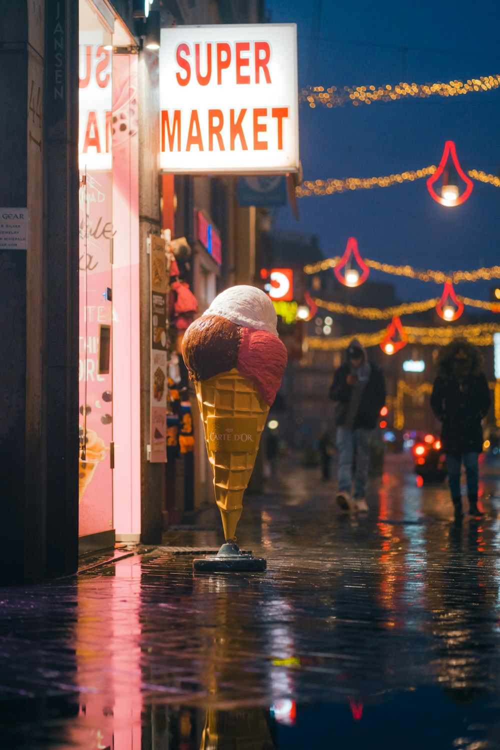 an ice cream cone on a city street at night