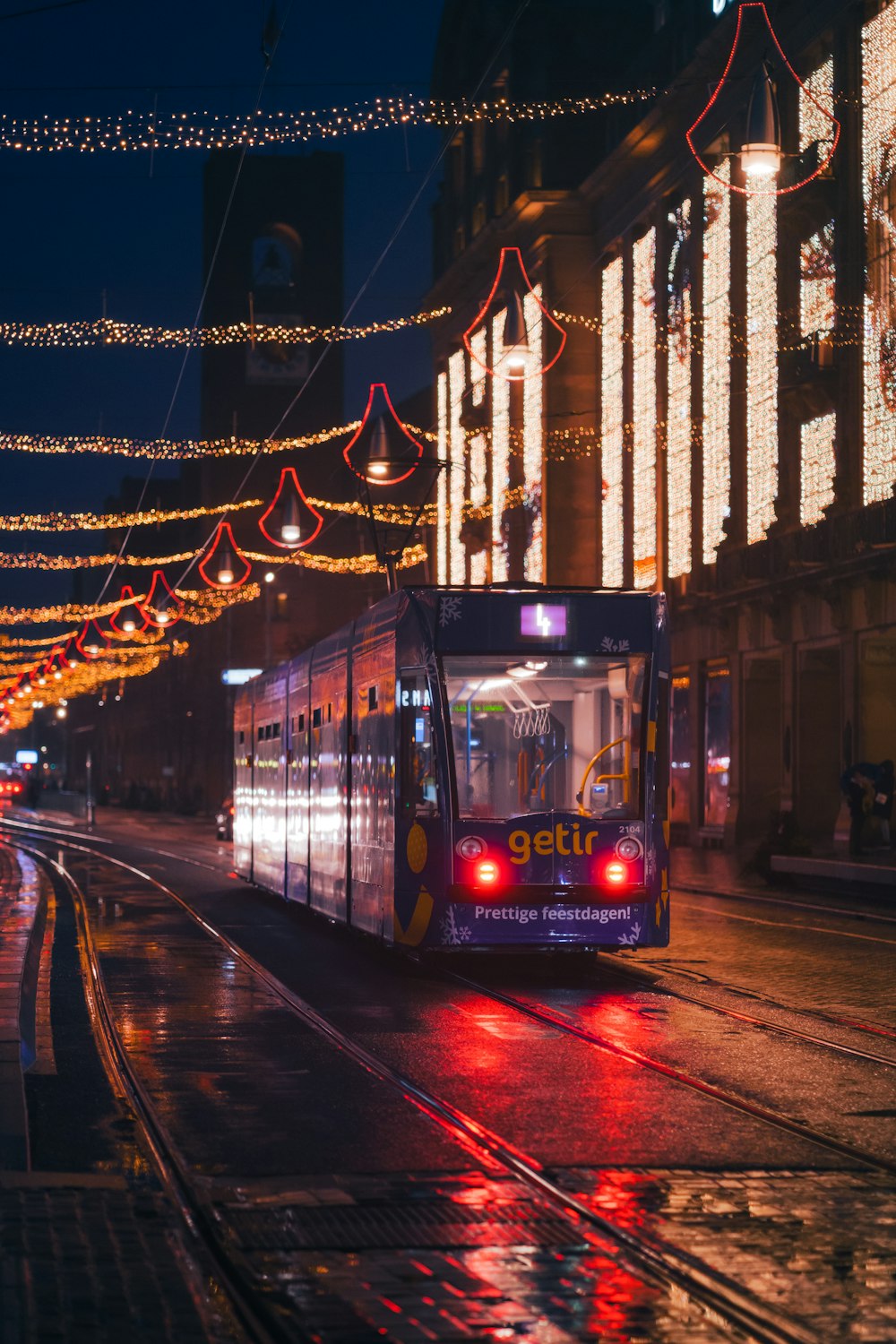 eine Straßenbahn auf einer Stadtstraße bei Nacht
