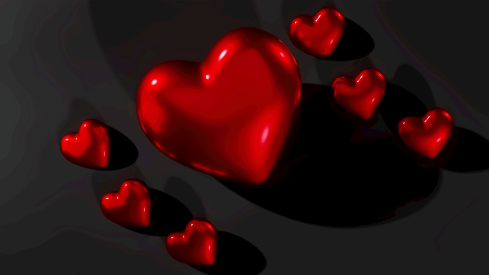 um grupo de corações vermelhos em um fundo preto