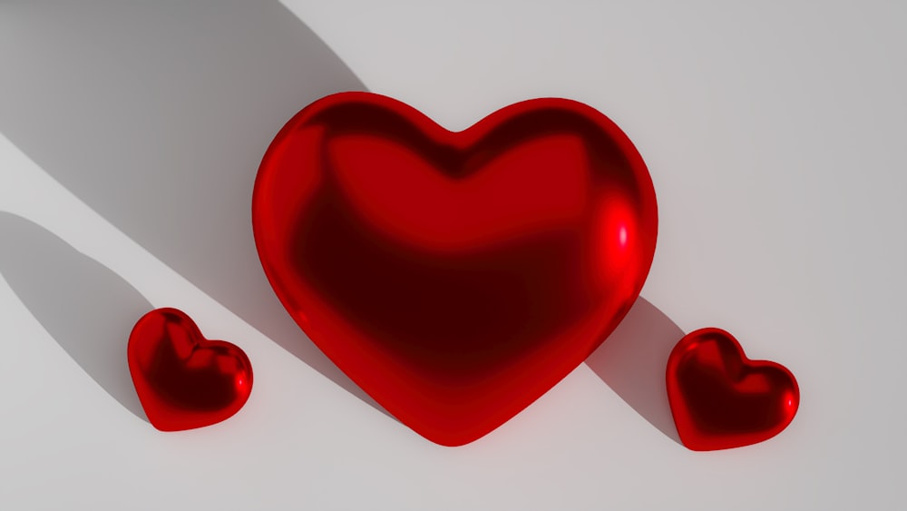 ein rotes Herz und drei kleinere Herzen auf weißem Grund