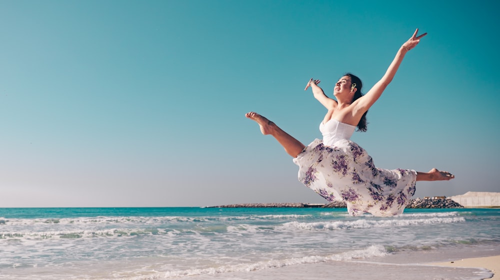 a woman jumping in the air on the beach