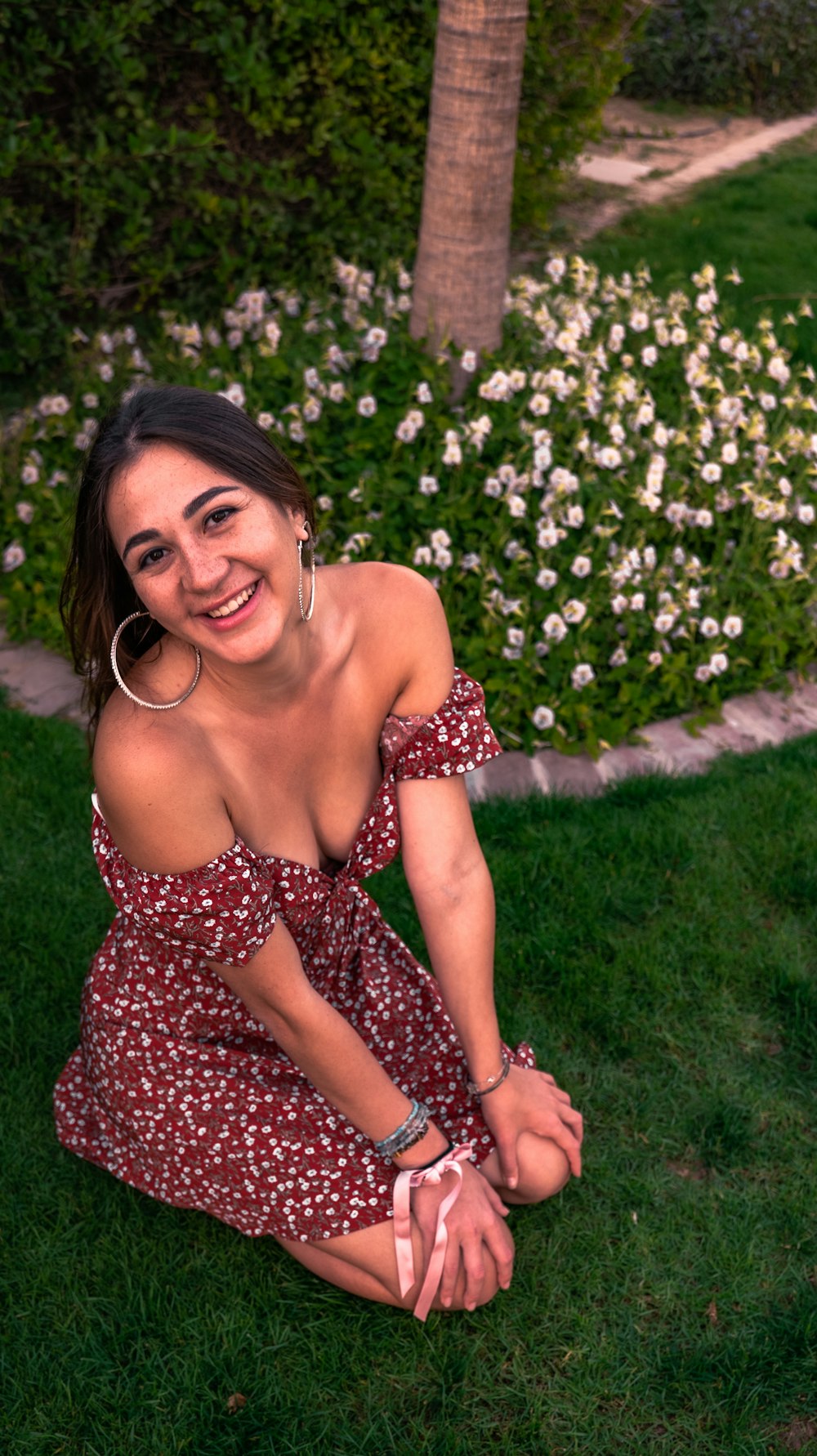 a woman sitting on the grass in a dress