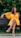 A stylish woman wearing a vibrant summer dress in a sunny park.