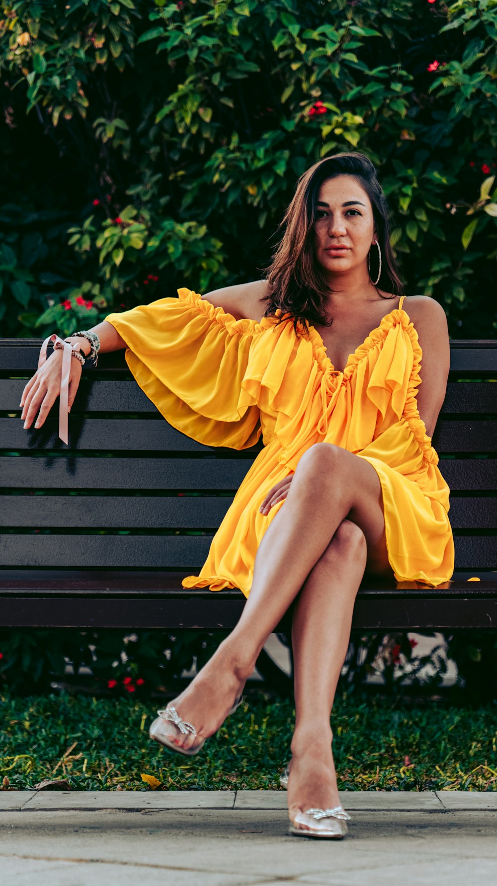 a woman in a yellow dress sitting on a bench