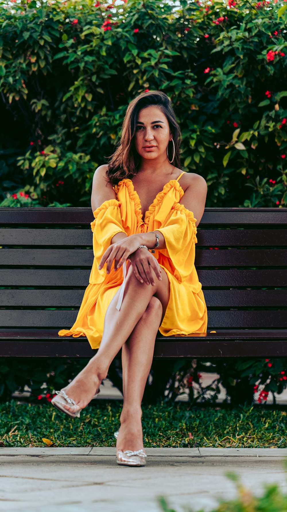 a woman in a yellow dress sitting on a bench