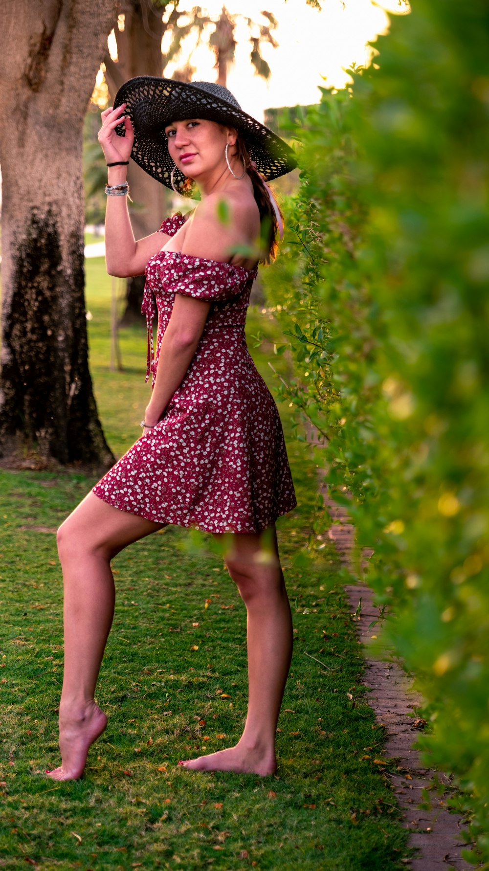 a woman in a dress and hat posing for a picture