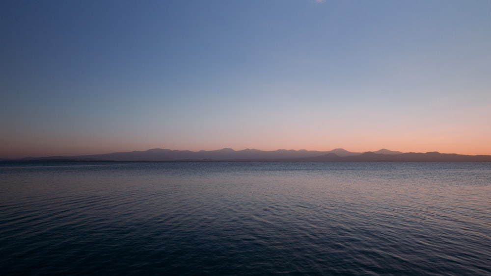 a body of water with mountains in the distance