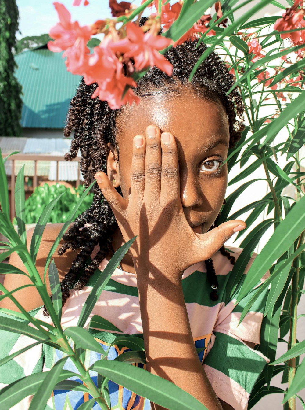 a young girl holding her hands up to her face