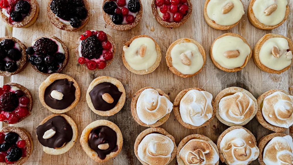 un tavolo di legno sormontato da un sacco di pasticcini