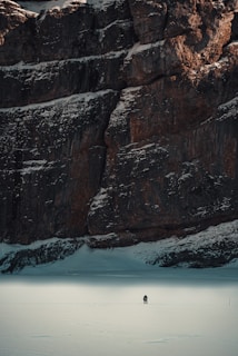 An icy frontier with a lone explorer trekking across a sparkling frozen expanse