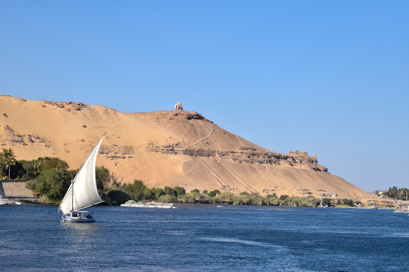 Felucca sailboat on the Nile near Aswan with desert hills beyond