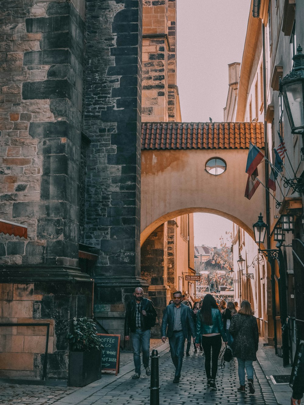 a group of people walking down a cobblestone street