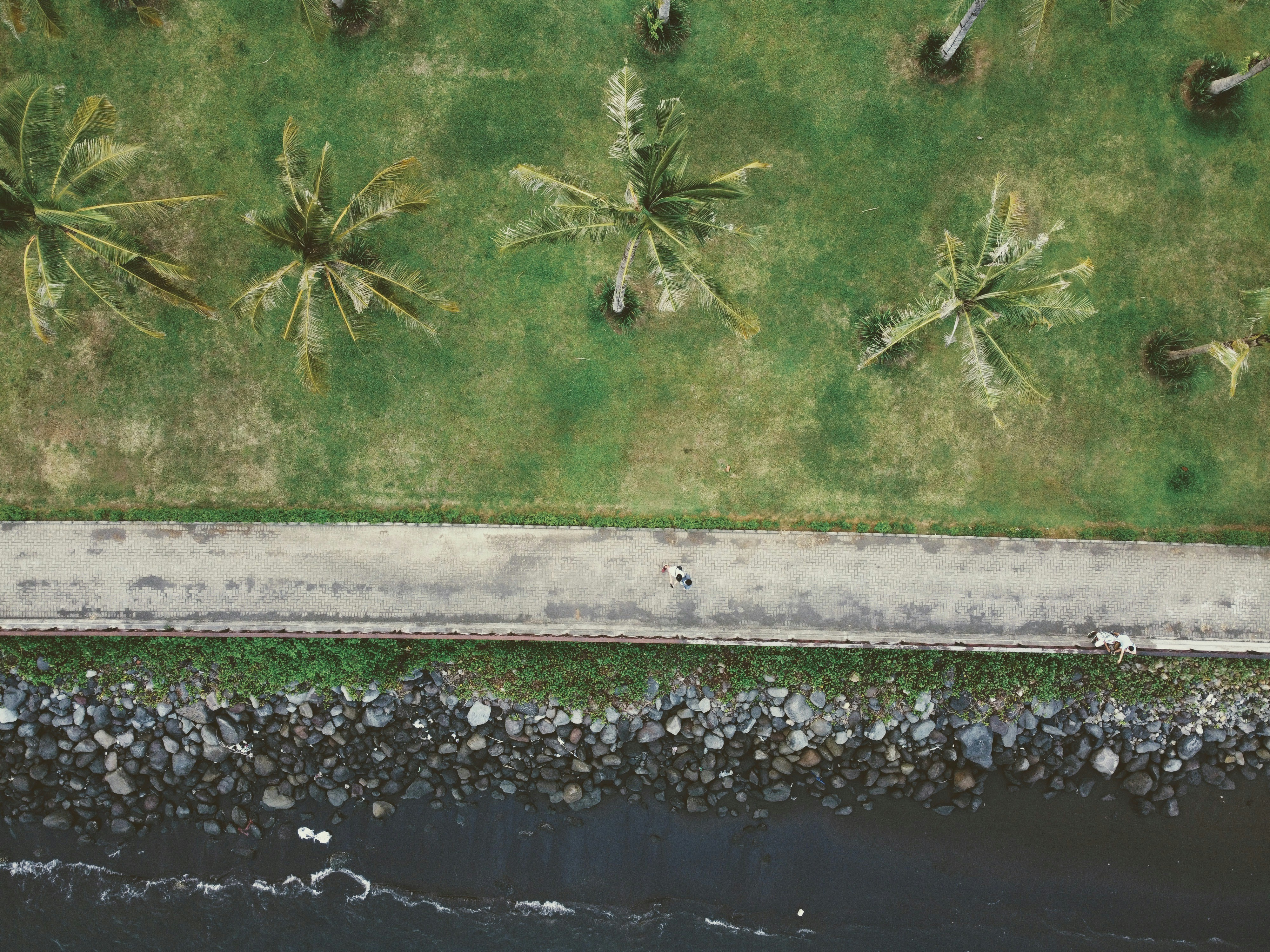 an aerial view of a man riding a bike down a street