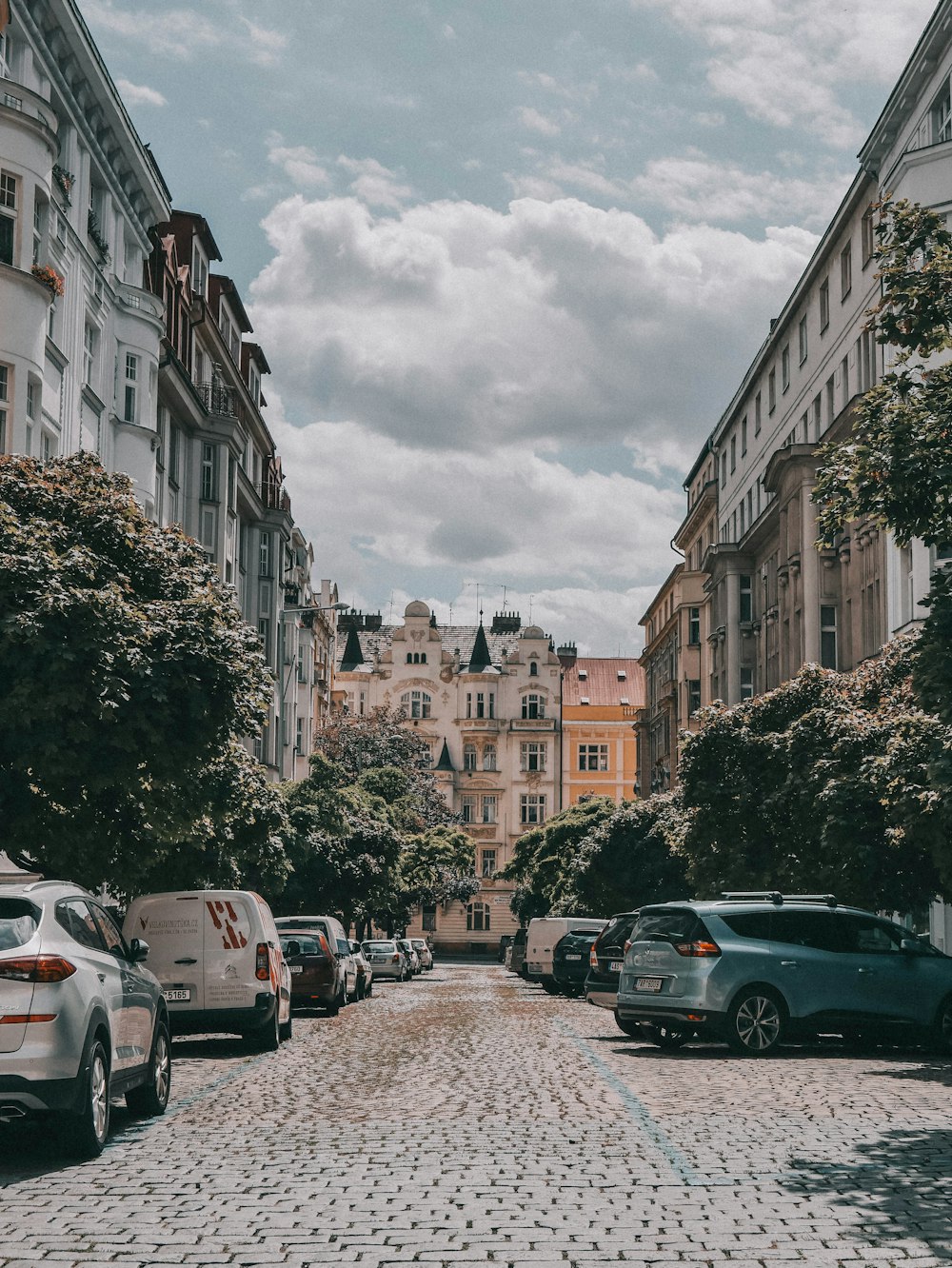 a cobblestone street lined with parked cars