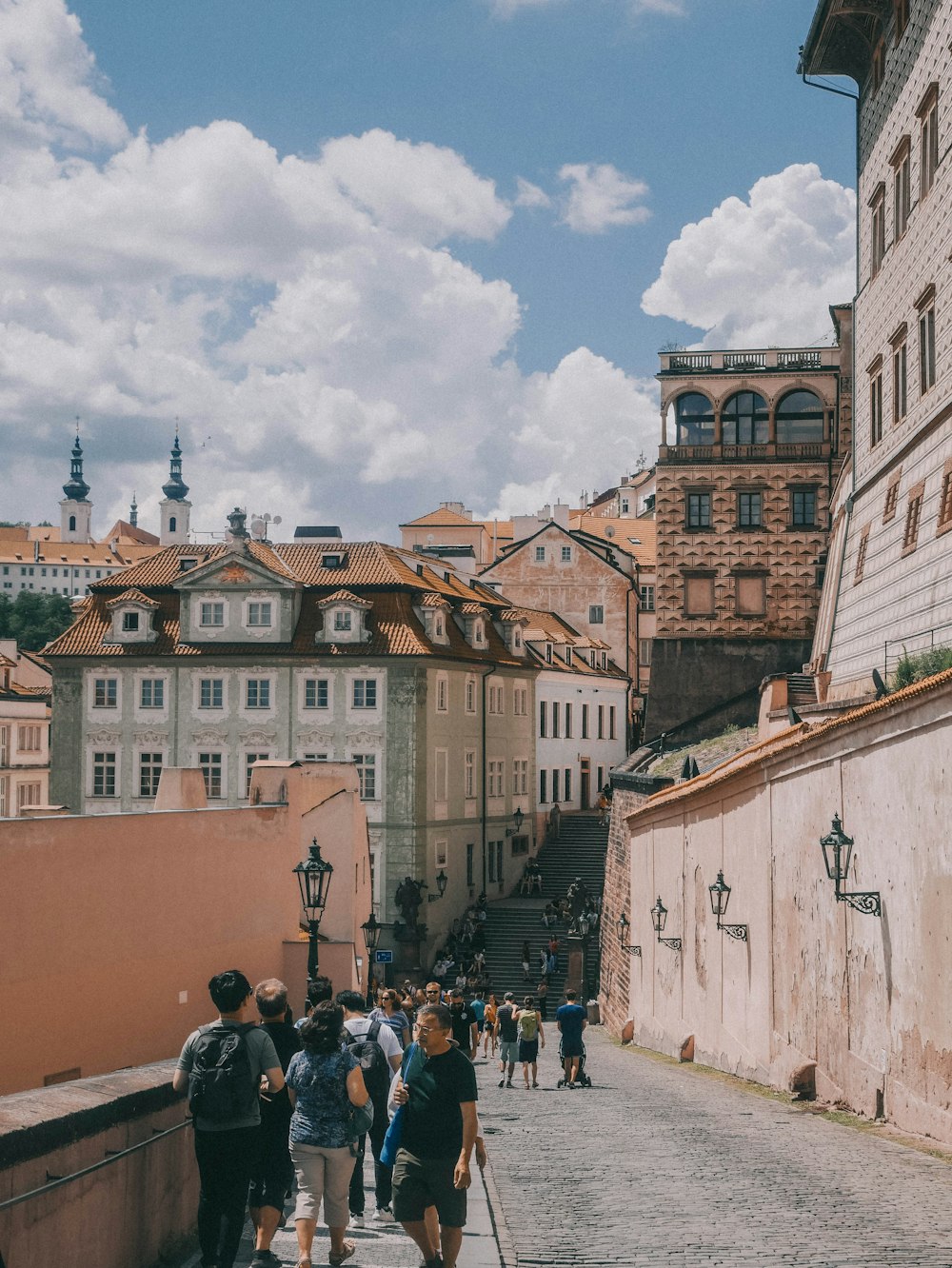 a group of people walking down a street next to tall buildings