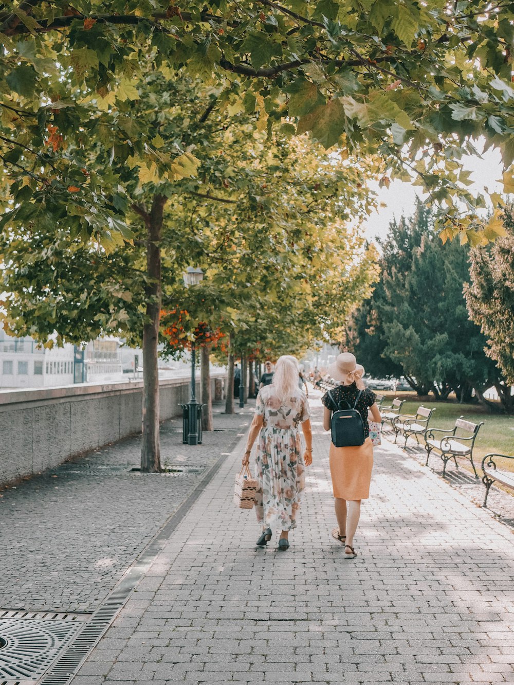 a couple of women walking down a sidewalk