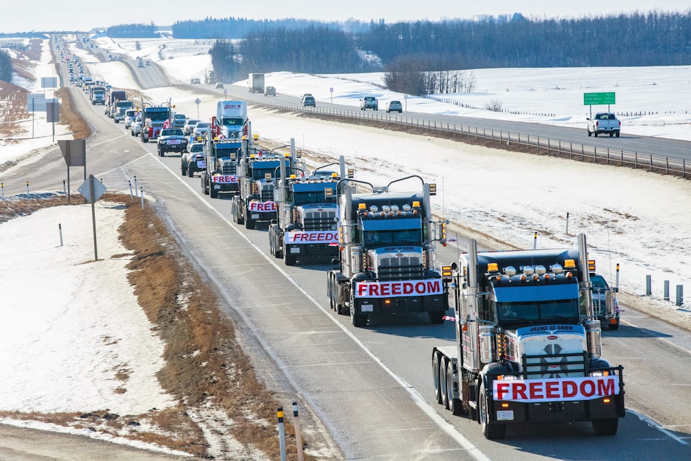 a long line of trucks driving down a highway