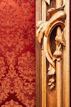a gold door handle on a red wall