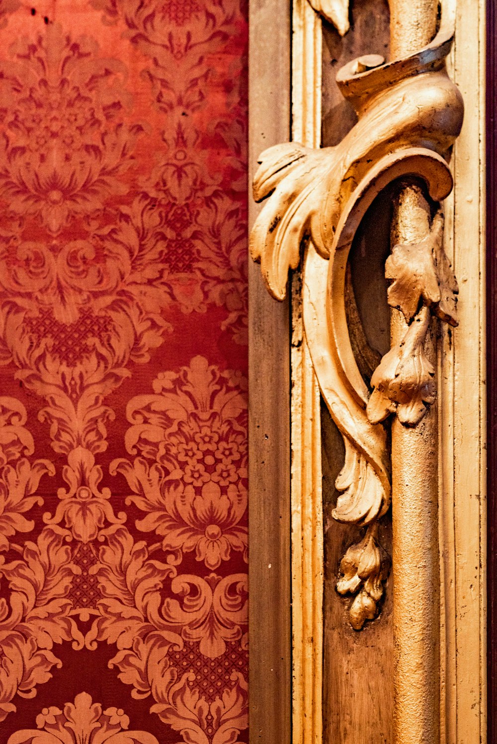 a gold door handle on a red wall