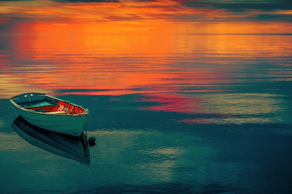 a small boat floating on top of a body of water