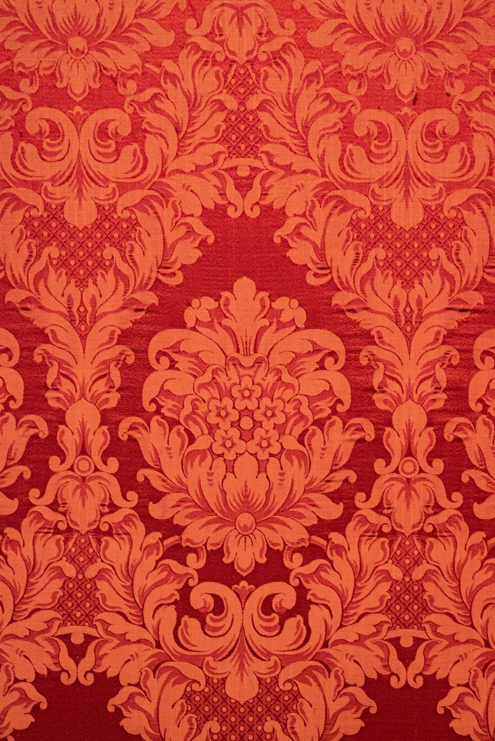 a red and orange wallpaper with a floral design
