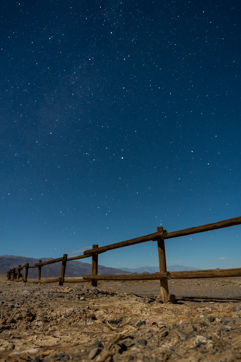 a wooden fence in the middle of a desert