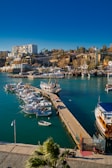 a harbor filled with lots of boats next to a city