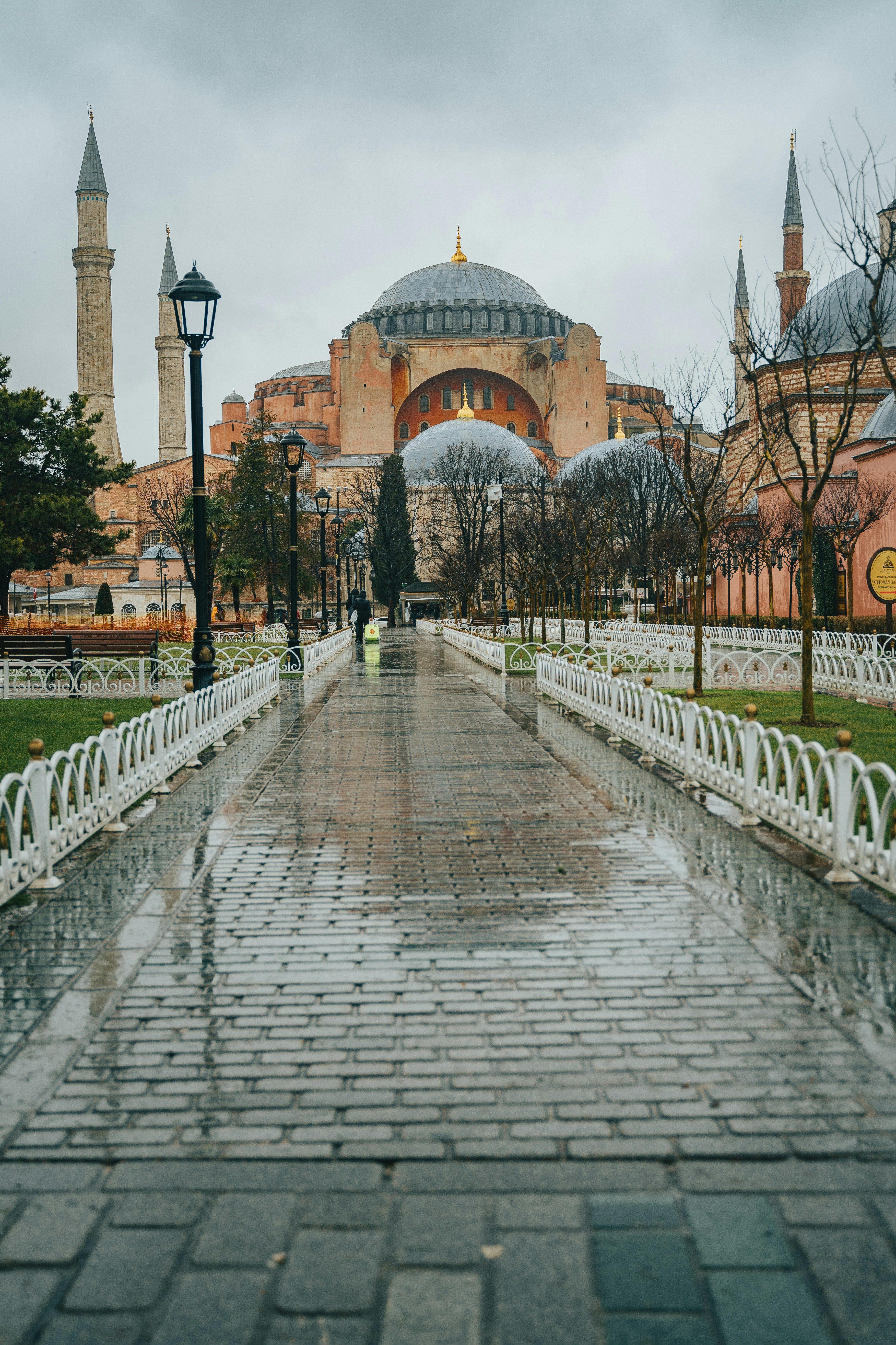 a walkway leading to a large building in the rain