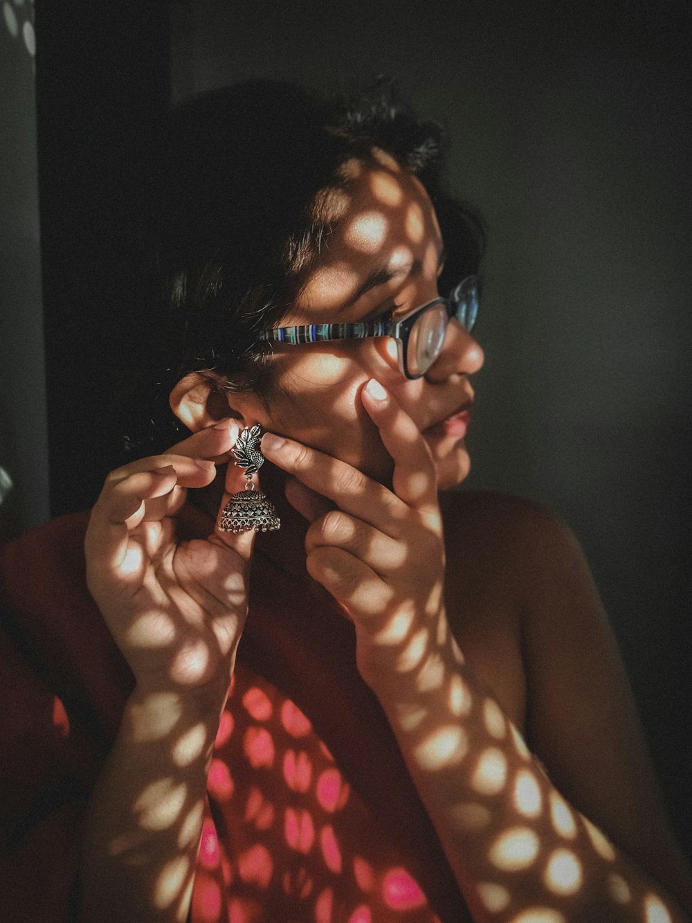 a woman wearing glasses and a red shirt