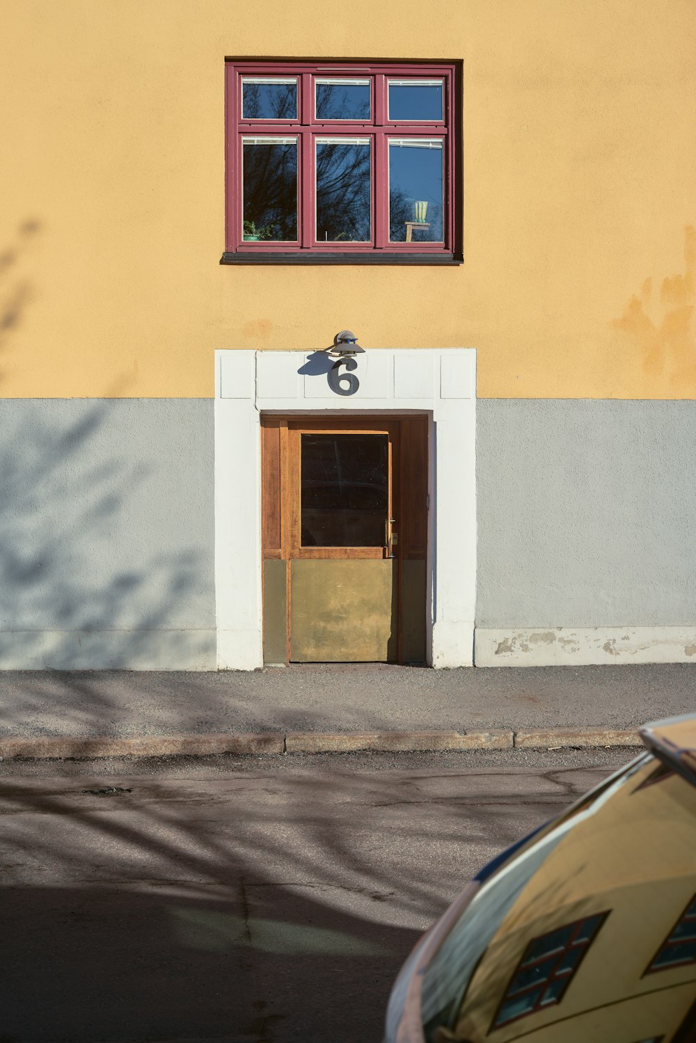 a car parked in front of a yellow building